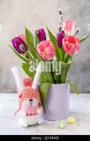 Bouquet of pink and purple tulips with colorful quail eggs. Spring and Easter holiday concept. Stock Photo
