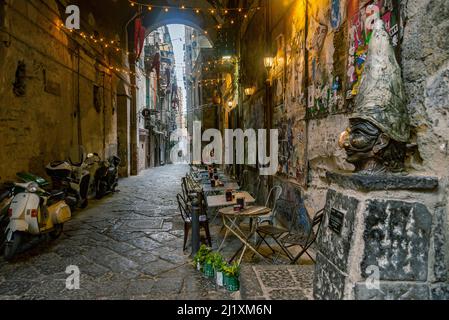 NAPLES, ITALY - JANUARY 2, 2022: narrow streets of the histrorical center, the traditional mask with face of Pulcinella in the old town of Naples, Cam Stock Photo