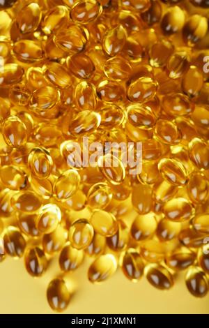 The texture of the capsules in the shell with liquid vitamin D3 in full screen. Gold capsules with a dietary supplement for joints teeth and bones. Stock Photo