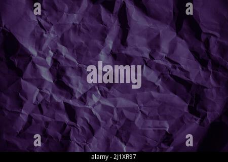 Purple crumpled paper texture in low light background Stock Photo
