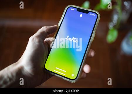 Bangkok, Thailand - March 18, 2022: Apple iPhone 13 showing its screen with "Hello", when the iOS has been updated to 15.4 version. Stock Photo