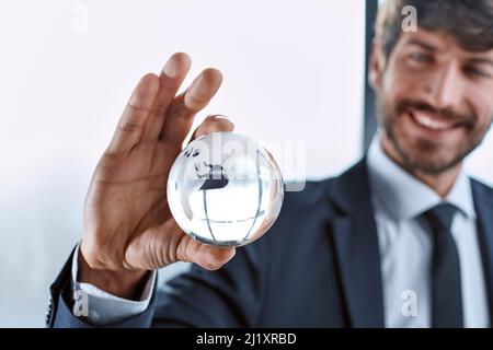 businessman looking at the glass globe in his hand . Stock Photo