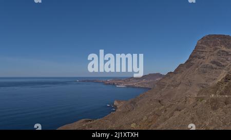 Beautiful view over the western coast of island Gran Canaria, Canary Islands, Spain with steep cliffs and village Puerto de las Nieves in background. Stock Photo