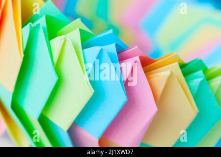 Abstract colorful origami background, parametric ring structure of linked paper sheets, close up photo with selective focus