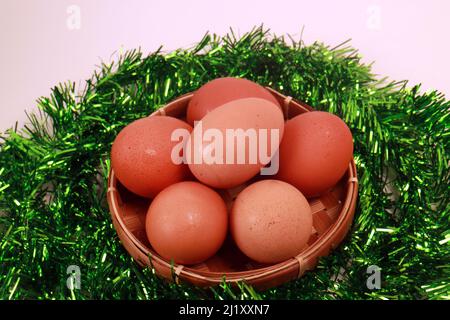 Studio photo of Easter Close-Up of Eggs in a Basket Green Vines on white background Stock Photo