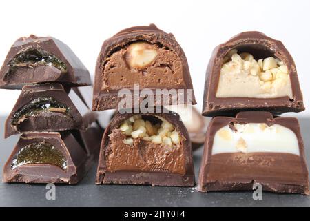 background of candy candy chocolate. sweets in section with fillings of praline ganache with peanuts whole crushed close-up. A day without diet sweet Stock Photo