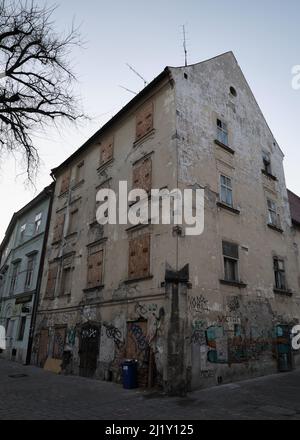 Boarded-up old building with graffiti on a quiet street in Bratislava, Slovakia. Stock Photo
