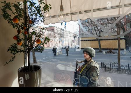 Kyiv, Kyiv, Ukraine. 28th Mar, 2022. A Ukrainian soldier standing guard at a checkpoint looks at a citrus tree of mandarins in downtown Kyiv, amid the Russian Invasion. Attacks on the capital Kyiv and other cities have recently been intensifying. (Credit Image: © Daniel Ceng Shou-Yi/ZUMA Press Wire) Stock Photo