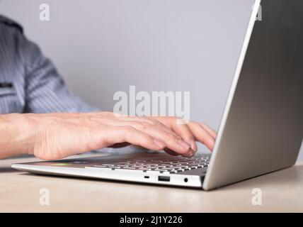 Man hands closeup typing on laptop keyboard. Using computer in common life, education, work, rest, social communication and shopping. High quality photo Stock Photo
