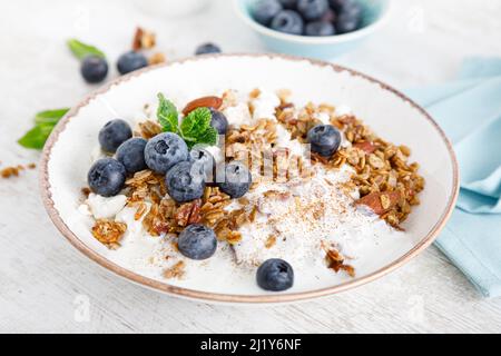 Bowl of granola with fresh blueberry, cottage cheese or curd, yogurt and nuts. Healthy food. Breakfast Stock Photo