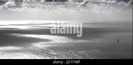 Catamaran Yacht slips away from Mustique on chrome seas Stock Photo