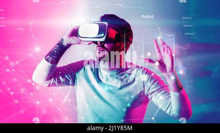 Young guy in virtual reality glasses, having fascinating virtual reality experience, double exposure creative image Stock Photo