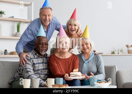 International group of elderly people having birthday party at home Stock Photo
