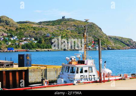 Pilot boat docked at a pier, St. John's Harbour. Signal Hill and Cabot Tower in background. Stock Photo