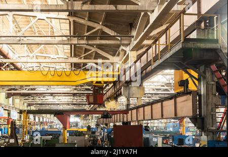The interior of an old manufacturing plant. Large hangar in a factory with many special machines and technological equipment without people Stock Photo