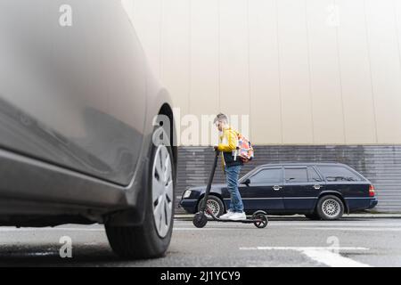 Modern teenager rides on electric scooter Stock Photo