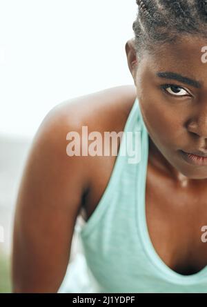 Stay focused on your goal. Shot of a young woman resting while running. Stock Photo