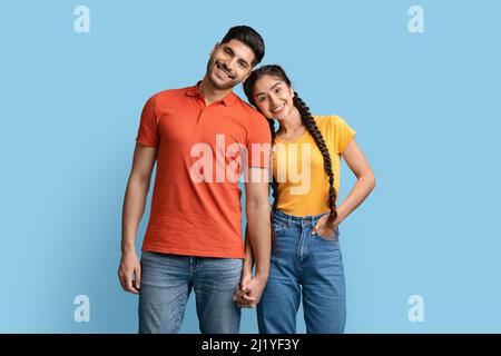 Portrait of happy middle eastern couple holding hands and looking at camera Stock Photo