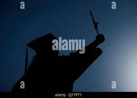 The sky is not the limit - its just the beginning. Shot of the silhouette of a student celebrating on graduation day. Stock Photo