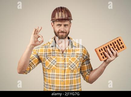 professional bricklayer show ok gesture. builder engineer. labor or workers day. Stock Photo