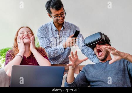 Young people having fun with new technology vr headset goggles, university students using a virtual reality game program Stock Photo
