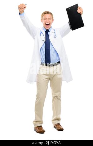 Youre cancer free. Full length shot of a handsome young doctor standing alone in the studio and holding a clipboard while celebrating. Stock Photo