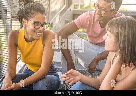 three happy people chatting, youth generation z lifestyle, multicultural group having fun outdoor Stock Photo