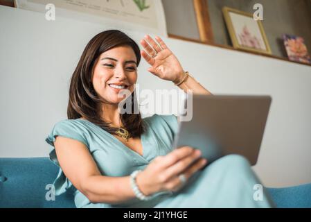 Portrait of a businesswoman greeting in a video call at home Stock Photo