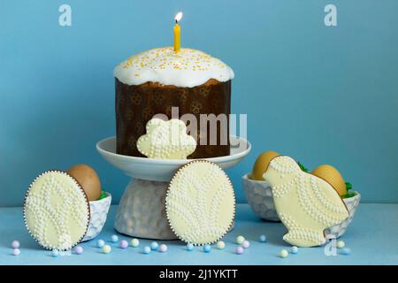 Easter composition, traditional Easter cake, colored eggs and gingerbread on a blue background. Stock Photo