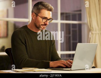 Focused on getting his business up and running. Cropped shot of a handsome mature businessman working on his laptop at home. Stock Photo