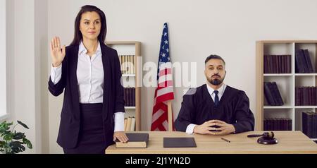 Witness swears on the Bible before giving a testimony during a trial in American court Stock Photo
