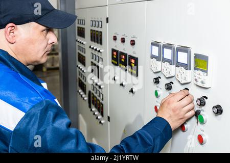 Hand pressing on green button of the machine in the factory Stock Photo