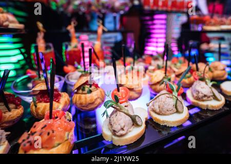 Beautifully decorated catering banquet table with different food snacks and appetizers with sandwich, on corporate christmas party event or wedding ce Stock Photo