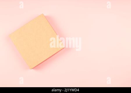 One brown cardboard box on pastel pink background. Mock up. Top view, copy space for text or image Stock Photo