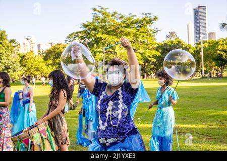 Goiânia, Goias, Brazil – March 01, 2022: A girl blowing giant soap bubbles. Photo taken during the street Carnival in a public park in the city. Stock Photo