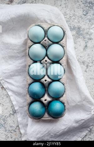 Dyed blue Easter eggs painted with natural dye red cabbage on grey concrete background. Row of ombre blue Easter eggs. Natural ecological staining wit Stock Photo