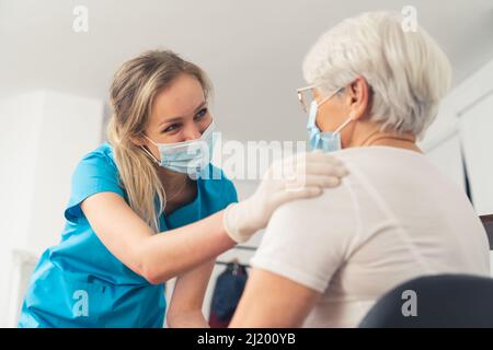 Friendly caucasian nurse supporting an elderly retired lady. . High quality photo Stock Photo
