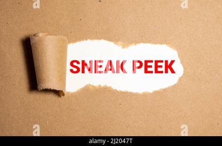 The phrase Sneak Peek appearing behind torn brown paper Stock Photo