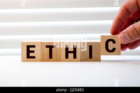 Wooden blocks with the word Ethic. Defending, systematizing and recommending concepts of right and wrong conduct. Moral philosophy. Stock Photo