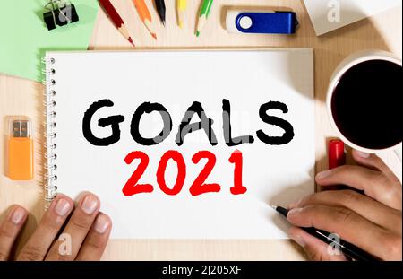 Goals 2021 text on opened notebook on the wood table, goal setting for coming year concept. Stock Photo