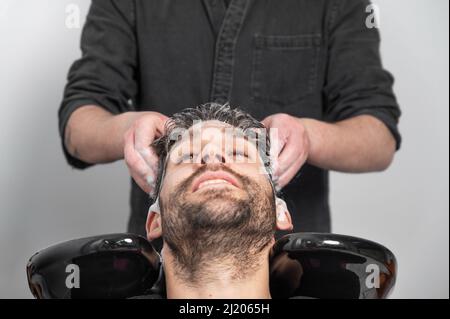 Barber shop. Hairdresser man washes client head in barbershop. High quality photography Stock Photo