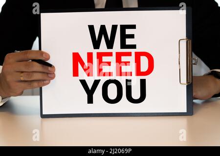 WE NEED YOU. message on the card shown by a man. Stock Photo