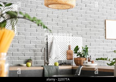 Stylish counter and pegboard on grey brick wall in modern kitchen Stock ...
