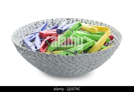 Wicker bowl with plastic clothes pins on white background Stock Photo