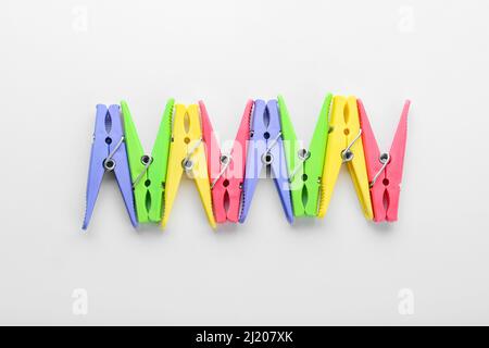 Plastic clothes pins on light background Stock Photo