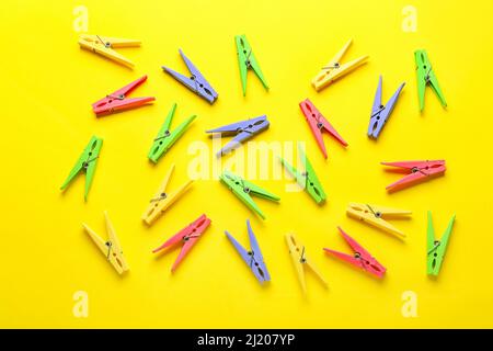 Plastic clothes pins on color background Stock Photo