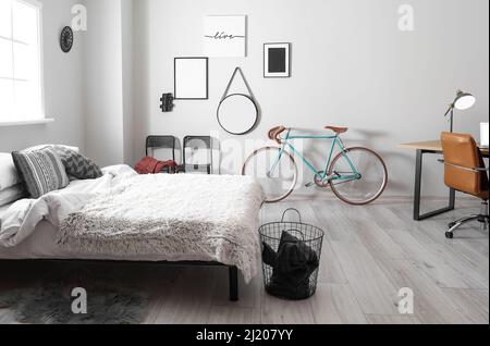 Interior of light bedroom with bicycle and modern workplace Stock Photo