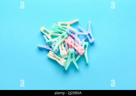 Plastic clothes pins on color background Stock Photo