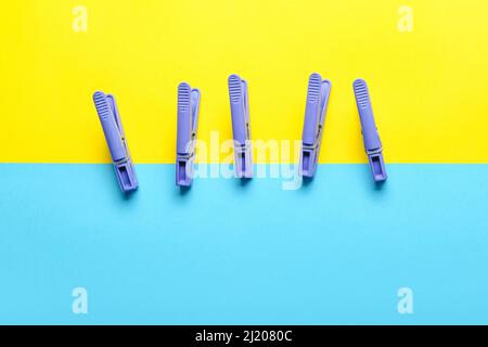 Plastic clothes pins on color background Stock Photo