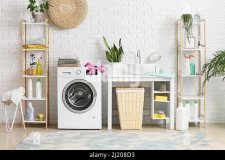 Stack of clean clothes on washing machine in laundry room Stock Photo